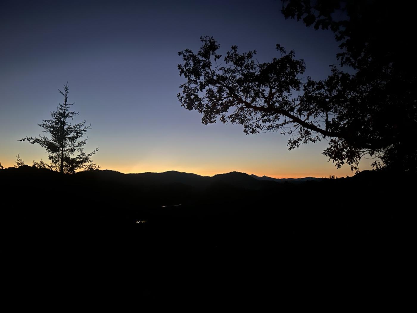 Sonnenuntergang über bewaldeten Hügeln